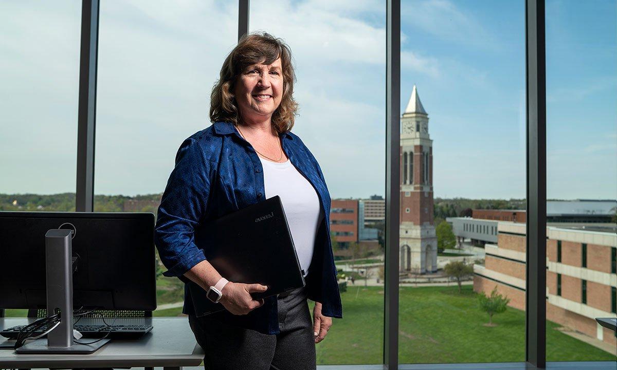 Woman standing in front of window with tower in background